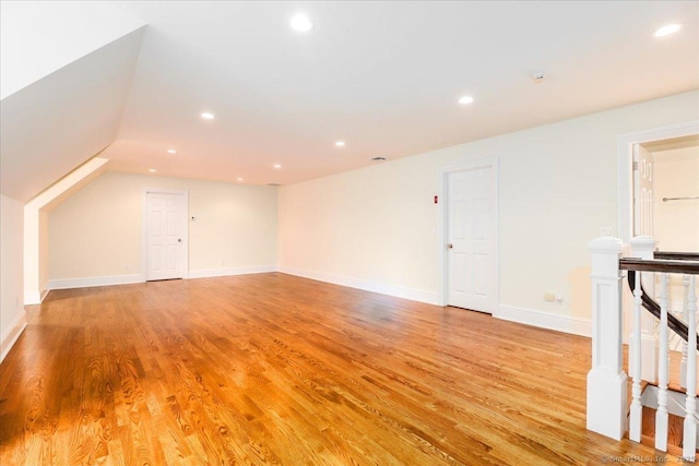 additional living space with baseboards, recessed lighting, light wood-style flooring, and vaulted ceiling