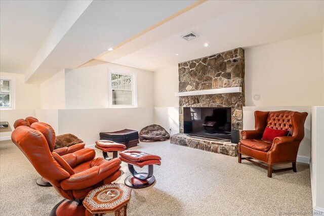 living area featuring a wealth of natural light, visible vents, baseboards, and carpet floors