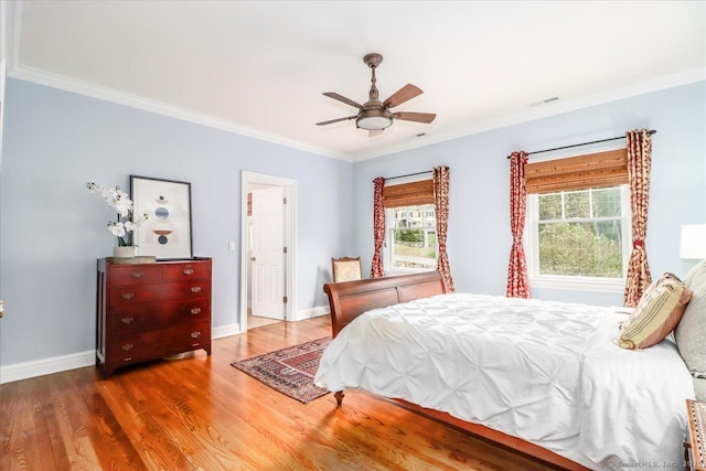 bedroom featuring visible vents, ceiling fan, baseboards, ornamental molding, and wood finished floors