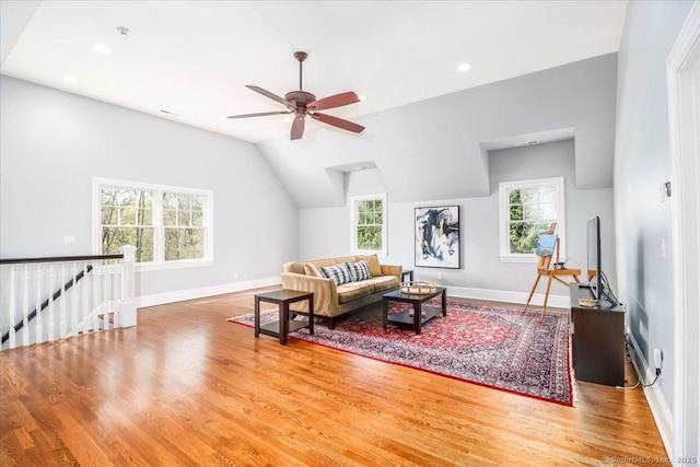 living area with baseboards, wood finished floors, a wealth of natural light, and ceiling fan