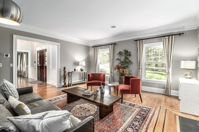 living room with crown molding, light wood finished floors, and a wealth of natural light