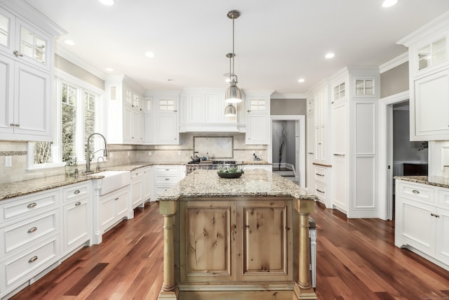 kitchen with dark wood-type flooring, a sink, white cabinets, and tasteful backsplash
