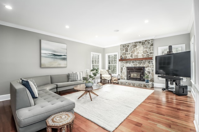 living area with wood finished floors, crown molding, and plenty of natural light