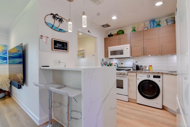 53 E Broadway Unit D, Milford, CT 06460 - kitchen featuring light wood-style floors, a kitchen bar, washer / dryer, crown molding, and white appliances