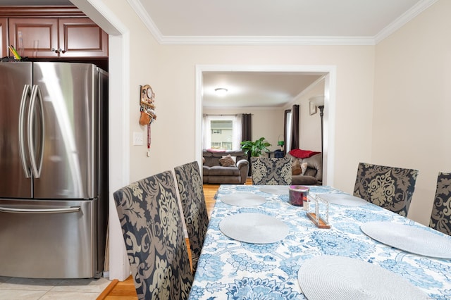 dining area featuring light wood-type flooring and ornamental molding