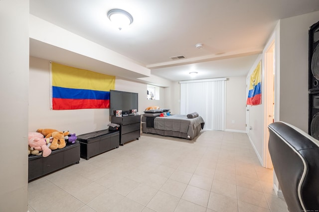 bedroom featuring light tile patterned floors, visible vents, and baseboards