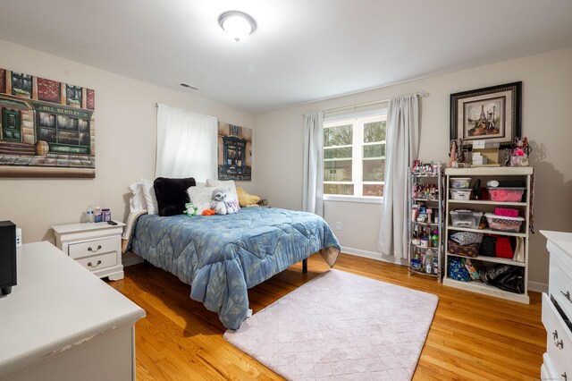 bedroom featuring visible vents, baseboards, and light wood-style floors