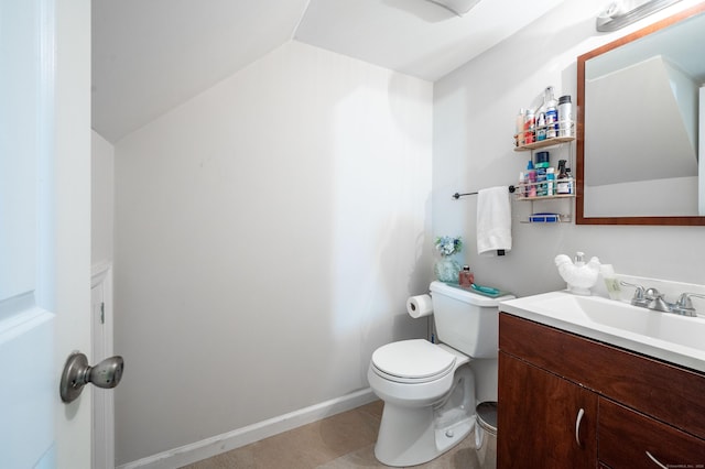 bathroom with lofted ceiling, vanity, and toilet