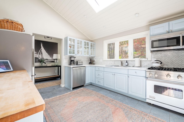 70 N Lake Shore Dr, Brookfield, CT 06804 - kitchen with a sink, vaulted ceiling with skylight, stainless steel appliances, decorative backsplash, and glass insert cabinets