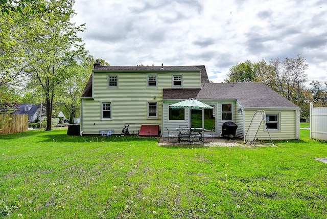 back of house featuring a patio area, a yard, and a chimney