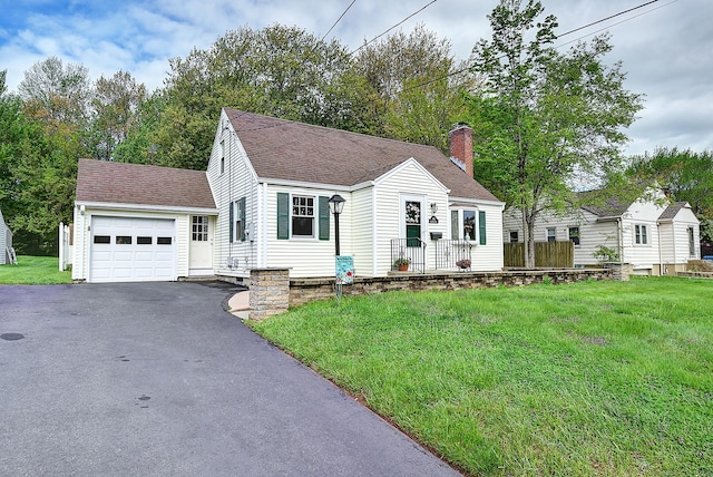 new england style home featuring driveway, an attached garage, a chimney, roof with shingles, and a front yard
