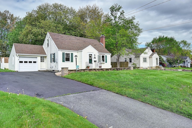 view of front of home featuring asphalt driveway, a shingled roof, a front yard, an attached garage, and a chimney