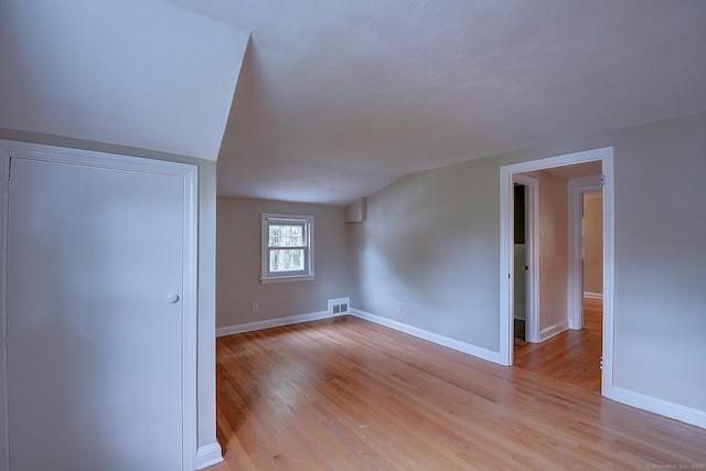 bonus room featuring light wood finished floors and baseboards