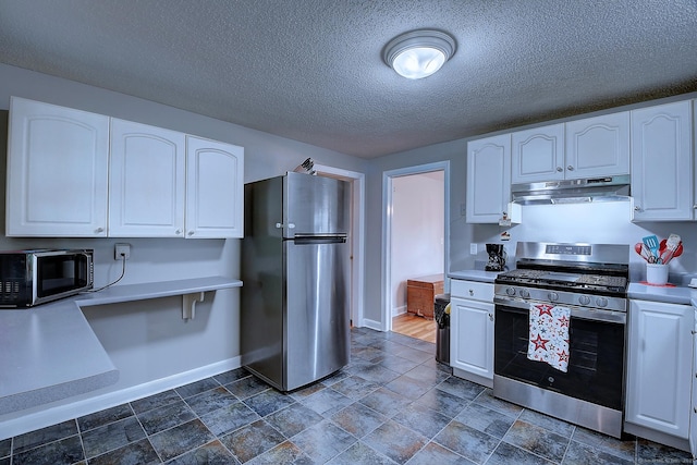 kitchen with stainless steel appliances, under cabinet range hood, white cabinets, light countertops, and a textured ceiling