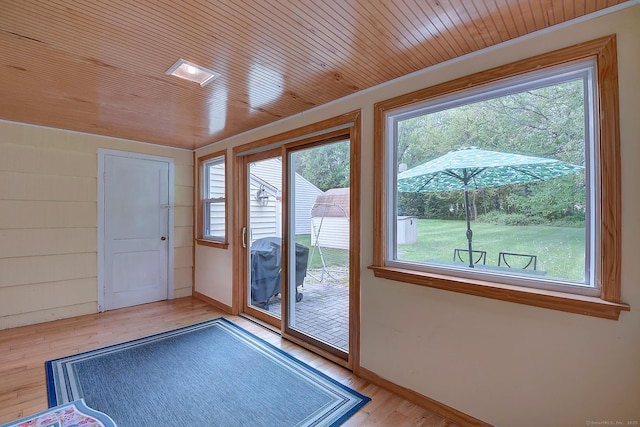 entryway featuring healthy amount of natural light, light wood-type flooring, baseboards, and wood ceiling