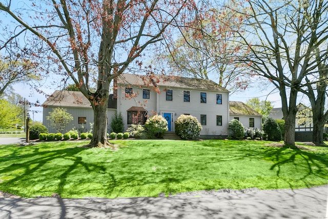 colonial inspired home with a front lawn