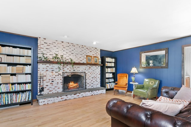 living area with a tiled fireplace and wood finished floors