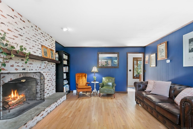 living area featuring baseboards, a fireplace, and hardwood / wood-style floors