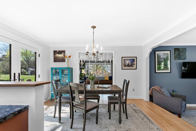 dining area with an inviting chandelier, ornamental molding, and a wealth of natural light