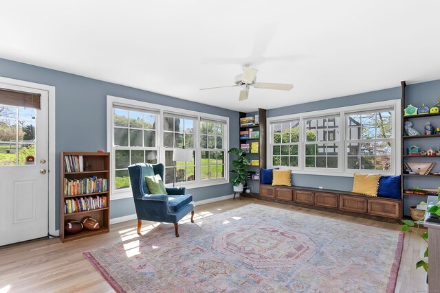 living area featuring a ceiling fan, plenty of natural light, and light wood-type flooring