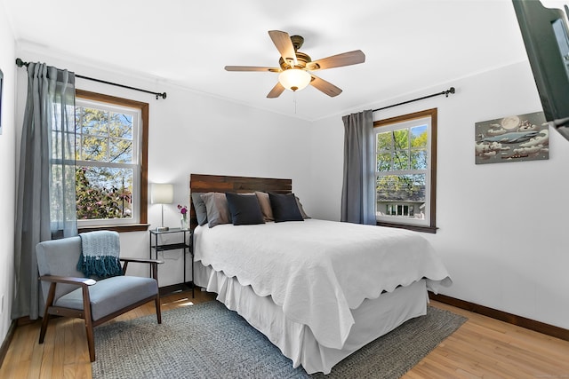 bedroom with baseboards, ornamental molding, light wood finished floors, and ceiling fan