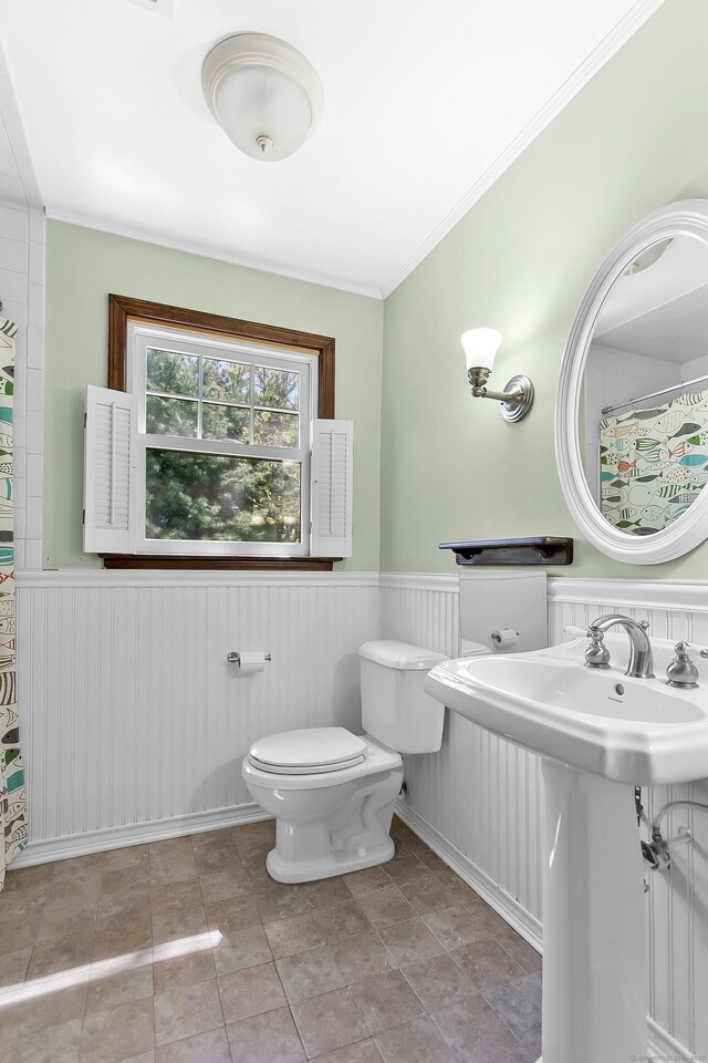 full bathroom with crown molding, wainscoting, a sink, toilet, and a shower with shower curtain