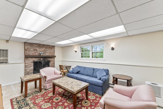 49 Birch Hill Rd, Newtown, CT 06470 - living area with a paneled ceiling, a brick fireplace, a decorative wall, heating unit, and a baseboard heating unit