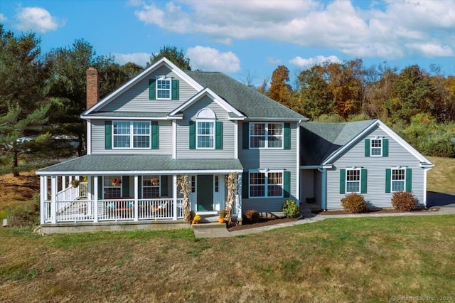 view of front of home featuring covered porch, a chimney, a shingled roof, and a front yard