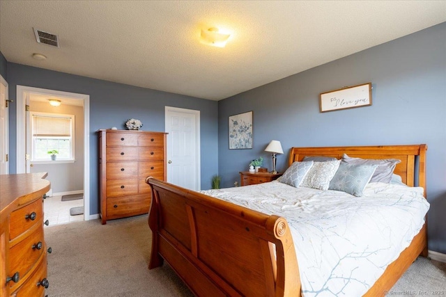 bedroom featuring baseboards, visible vents, and light carpet