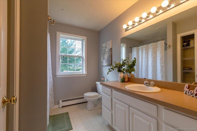 bathroom with vanity, toilet, baseboard heating, and baseboards