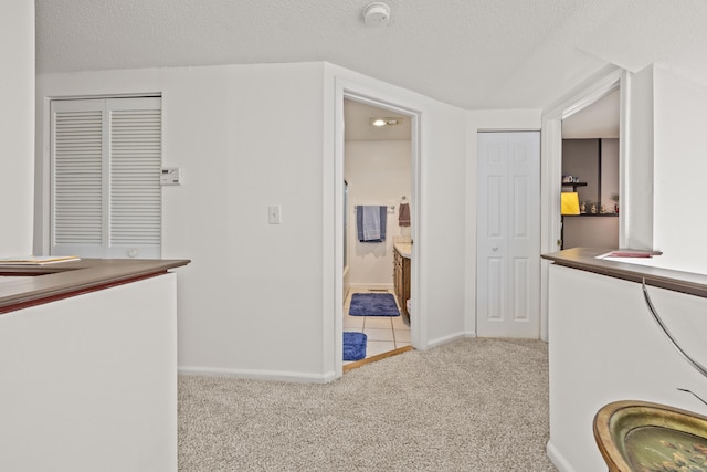clothes washing area featuring baseboards, a textured ceiling, and carpet