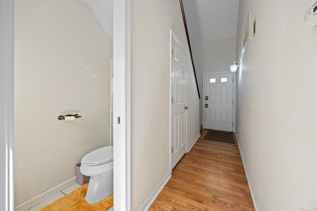 corridor featuring light wood-style floors and baseboards