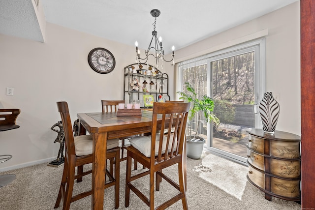 dining room featuring baseboards, a chandelier, and carpet