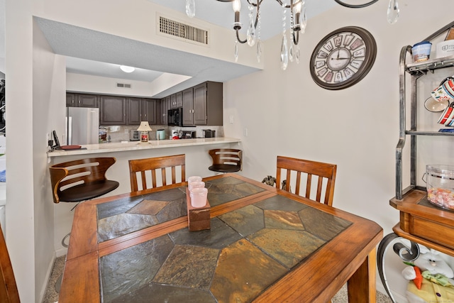 dining space with baseboards, visible vents, and stone finish floor