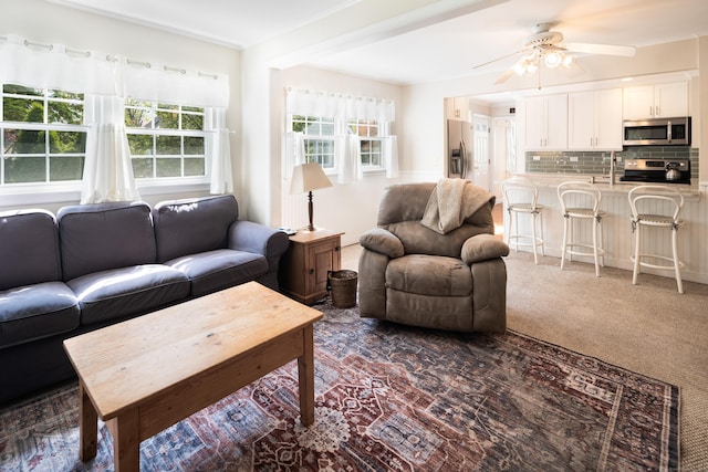 living area featuring dark colored carpet and a ceiling fan