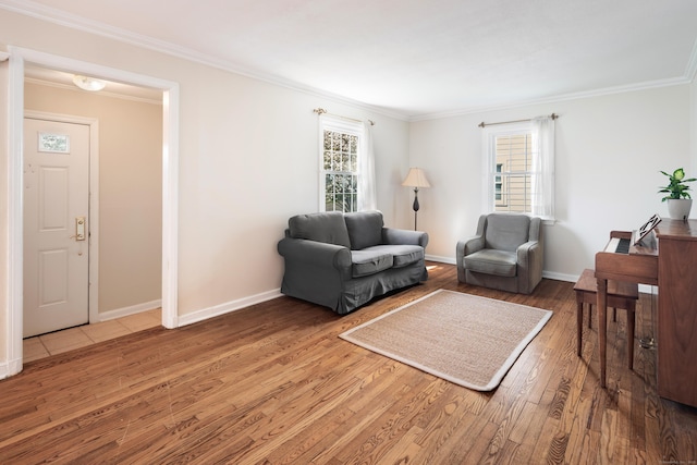living area featuring a healthy amount of sunlight, baseboards, ornamental molding, and wood finished floors