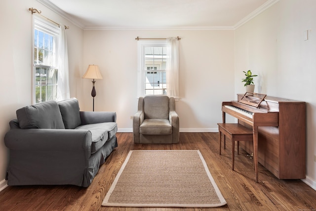 living area featuring ornamental molding, a healthy amount of sunlight, and wood finished floors