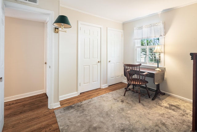 office space with crown molding, baseboards, visible vents, and wood finished floors