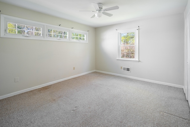 unfurnished room featuring baseboards, a ceiling fan, carpet flooring, and visible vents