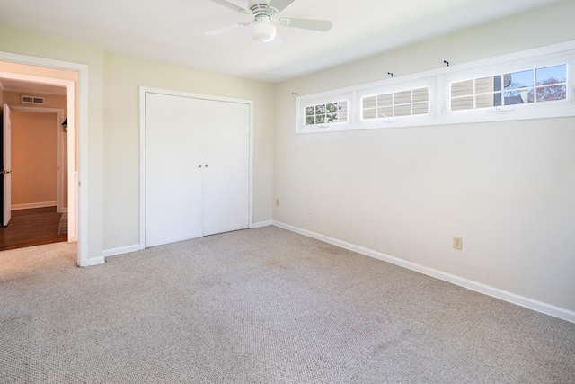 unfurnished bedroom featuring ceiling fan, visible vents, carpet floors, baseboards, and a closet