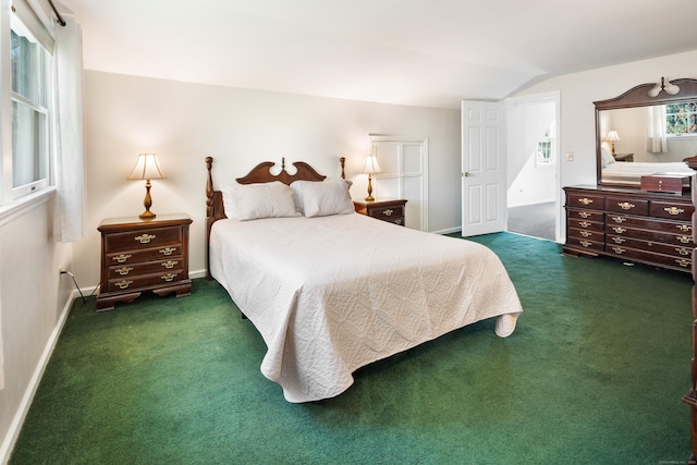 carpeted bedroom with baseboards and vaulted ceiling