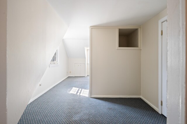 bonus room with baseboards and carpet