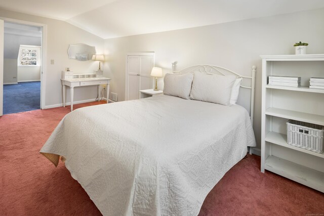 carpeted bedroom with baseboards, vaulted ceiling, and visible vents