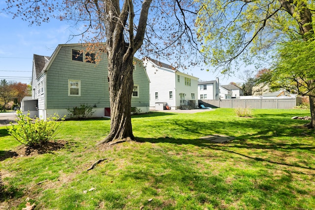 rear view of property featuring a yard and fence