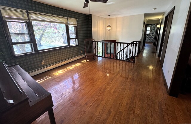 653 Andrew Mountain Rd, Naugatuck, CT 06770 - empty room with a baseboard radiator, ceiling fan, wallpapered walls, baseboards, and wood finished floors