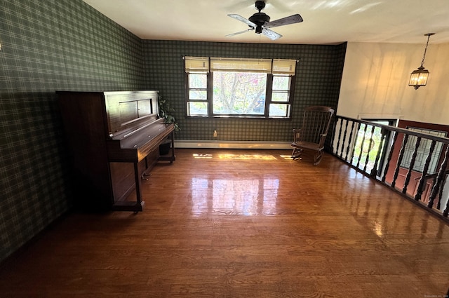 653 Andrew Mountain Rd, Naugatuck, CT 06770 - unfurnished room with a baseboard heating unit, a ceiling fan, wallpapered walls, and wood finished floors
