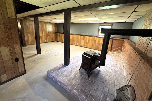653 Andrew Mountain Rd, Naugatuck, CT 06770 - basement with a wood stove, wooden walls, and a drop ceiling