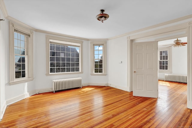 unfurnished room with radiator heating unit, crown molding, light wood-style flooring, and baseboards