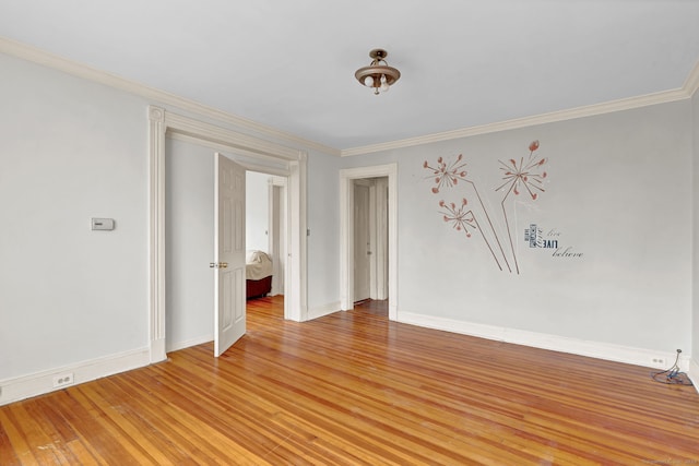 empty room with light wood-type flooring, ornamental molding, and baseboards