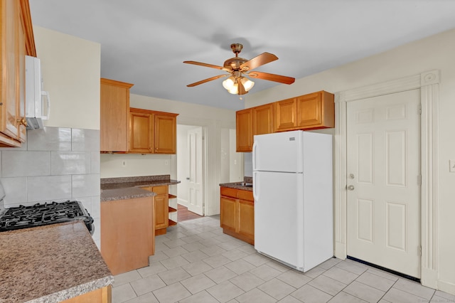 kitchen with tasteful backsplash, white appliances, a ceiling fan, and light tile patterned floors